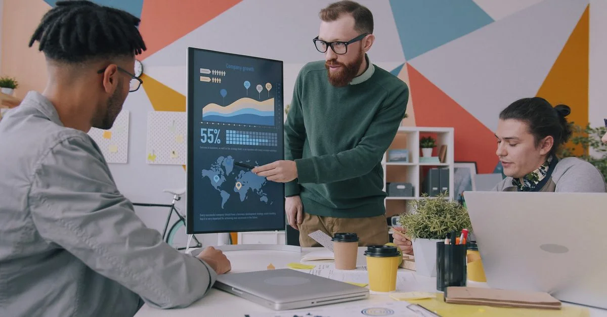 Collaboration d'équipe sur la stratégie de croissance de l'entreprise avec des graphiques de données dans un bureau moderne.
